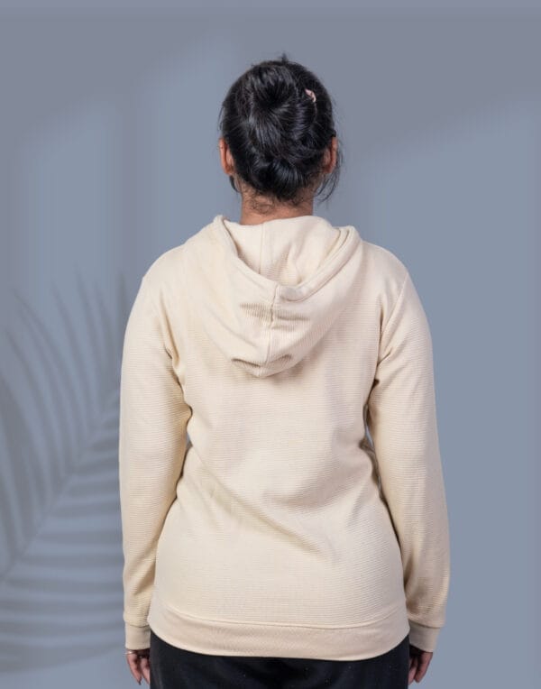 a woman wearing a beige hoodie